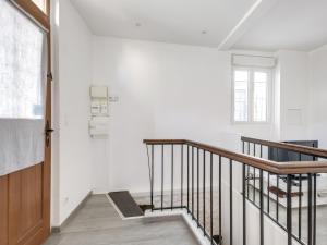 einen weißen Flur mit einer Treppe und einem Fenster in der Unterkunft Loft Fraternité in Bagnolet