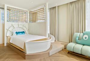 a bedroom with a bed and a chair at Grand Josun Busan in Busan