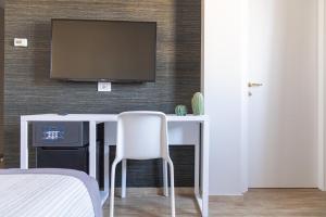a room with a desk with a television on a wall at Hotel Boston in Bari +36 photos
