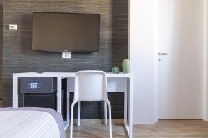 a room with a desk with a television on a wall at Hotel Boston in Bari