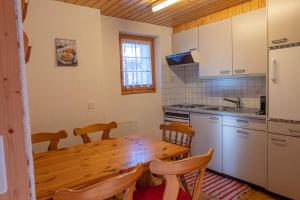 a kitchen with a wooden table with chairs and a wooden tableablish at Chalet Gerbera in Rosswald