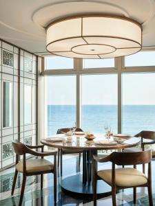 a dining room with a table and chairs and a large window at Grand Josun Busan in Busan