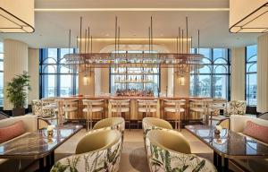 a restaurant with tables and chairs and a bar at Grand Josun Busan in Busan