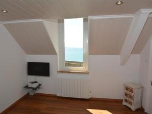 サン・マロにあるIntra Muros Vue Merの窓とテレビが備わる白い部屋