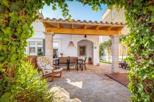 a patio with a wooden pergola and a table and chairs at Casa Mediterranea in Santa Margalida