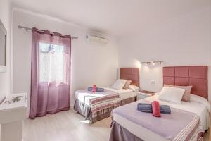 a room with two beds and a window at Casa Mediterranea in Santa Margalida