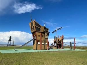 a playground with a house and a slide at Ferienwohnung am Deichweg in Cappel-Neufeld