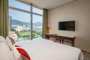 a hotel room with two beds and a desk and a window at Hotel 1936 in Hong Kong