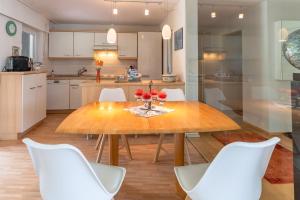eine Küche mit einem Holztisch und weißen Stühlen in der Unterkunft Haus Alpsee in Immenstadt im Allgäu