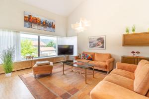 a living room with a couch and a tv at Haus Alpsee in Immenstadt im Allgäu