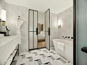 a bathroom with a white tub and a sink and a bath tub at Grand Josun Busan in Busan