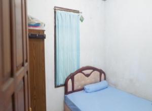 1 dormitorio con 2 camas, espejo y ventana en Aren Homestay, en Giripurno