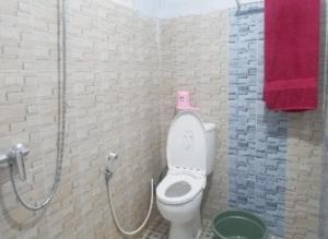 Baño con aseo con un objeto rosa. en Aren Homestay, en Giripurno