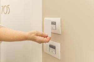 a person pressing a button on an electrical socket at Hotel Boston in Bari