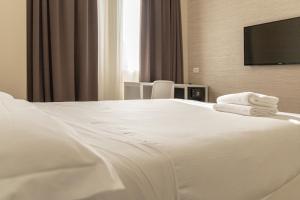 a hotel room with a television and a bed at Hotel Boston in Bari