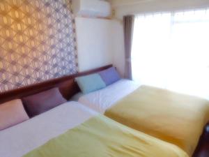 um quarto com 2 camas individuais ao lado de uma janela em SONIC APARTMENT HOTEL em Dazaifu