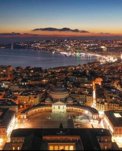 uitzicht op een stad in de nacht met de oceaan bij Casa Cupiello Via Chiaia - Casa Vacanze ad uso Esclusivo in Napels