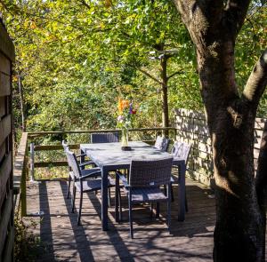 una mesa y sillas en una terraza con un árbol en Holiday Home Op 't Busselen, en Opoeteren