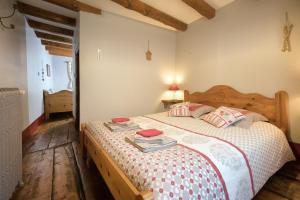 - une chambre avec un grand lit et une tête de lit en bois dans l'établissement Au Coeur Des Alpes, à Villarodin-Bourget