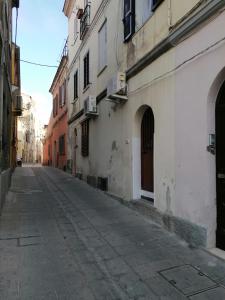 una calle vacía en un callejón entre edificios en Le antiche mura 2, en Sassari