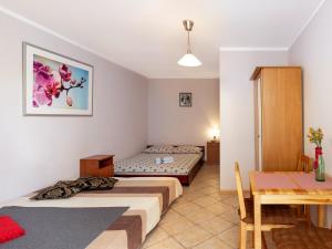 ヤストシェンビャ・グラにあるGościniec u Saryのベッド2台とテーブルが備わるホテルルームです。