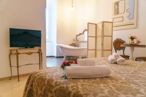 a bathroom with a tub and a bed with towels at Corte Pietrantica - Charming Rooms & Suites in Giovinazzo