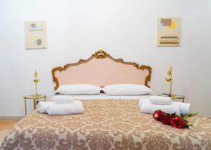 a bedroom with a large bed with red roses on it at Corte Pietrantica - Charming Rooms & Suites in Giovinazzo