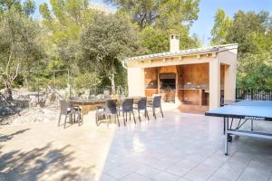 un patio avec une table, des chaises et un grill dans l'établissement Villa Luis Vives By SunVillas Mallorca, à Port de Pollença
