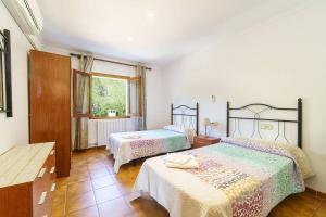 ein Schlafzimmer mit zwei Betten und einem Fenster in der Unterkunft Villa Luis Vives By SunVillas Mallorca in Port de Pollença + 26 Fotos