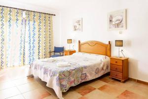 ein Schlafzimmer mit einem Bett, einer Kommode und einem Fenster in der Unterkunft Villa Luis Vives By SunVillas Mallorca in Port de Pollença