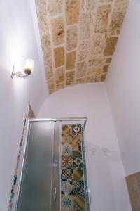 焦維納佐的住宿－Corte Pietrantica - Charming Rooms & Suites，一间带淋浴的浴室和瓷砖天花板
