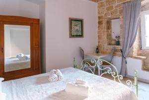 a bedroom with a bed with towels on it at Corte Pietrantica - Charming Rooms & Suites in Giovinazzo
