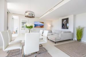 a living room with a couch and a table and chairs at The Edge Front Line Beach Luxury and Spa in Estepona