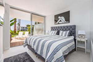 1 dormitorio con 1 cama grande y balcón en The Edge Front Line Beach Luxury and Spa en Estepona