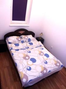 a small bed in a room with a bedspread on it at Apartment Old Town Cozy in Elblag