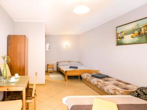 a living room with two beds and a table at Gościniec u Sary in Jastrzębia Góra