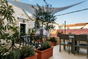 uma varanda com mesa, cadeiras e plantas em Divota Apartment Hotel em Split