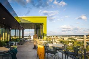 a balcony of a restaurant with tables and chairs at Original Sokos Hotel Kupittaa in Turku
