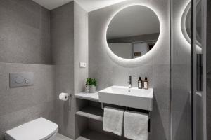 a bathroom with a sink and a toilet and a mirror at Botanique Hotel Prague in Prague