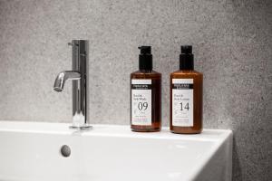 two bottles of soap sitting on top of a sink at Botanique Hotel Prague in Prague