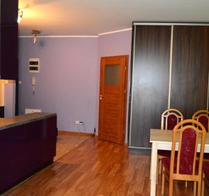 a kitchen and dining room with a table and chairs at Apartment Old Town Cozy in Elblag