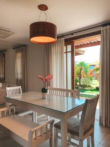 a dining room with a glass table and chairs at Casa Reserva Praia do Forte 2 quartos Conforto e Charme in Praia do Forte