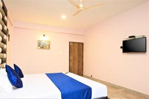 a bedroom with a bed and a flat screen tv at Casa Da Village Calangute Goa in Calangute