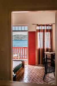 a bedroom with a red door and a view of the ocean at Dream Boathouse in Klima