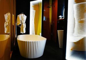 a white bath tub sitting next to a white toilet at Malmaison Hotel Leeds in Leeds