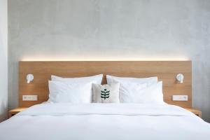 a bedroom with a white bed with white pillows at Botanique Hotel Prague in Prague