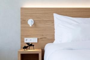 a bedroom with a bed and a lamp on a night stand at Botanique Hotel Prague in Prague