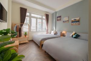 um quarto de hotel com duas camas e uma janela em Moc Thach Hostel Dalat em Da Lat