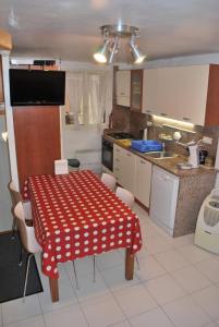 a kitchen with a red and white table and chairs at L'Appart in Bonifacio