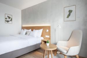 a bedroom with a bed and a chair and a table at Botanique Hotel Prague in Prague